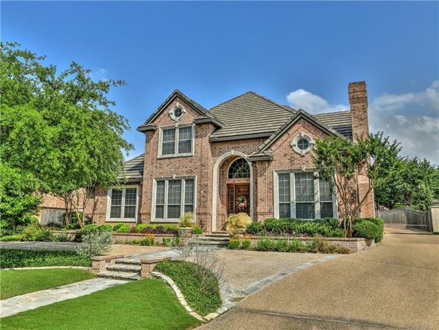Beautiful brick home in Fort Worth with a prominent pitched roof and landscaped front yard